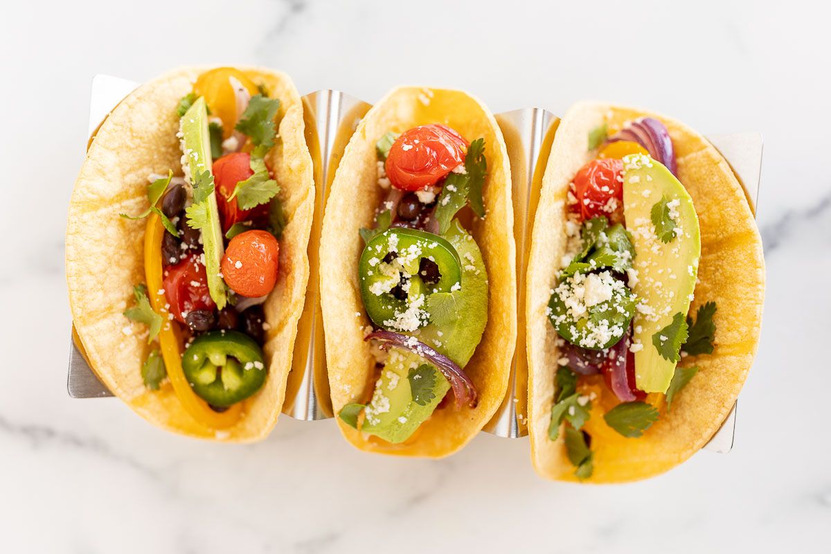 A plate of vegetarian tacos in corn tortillas