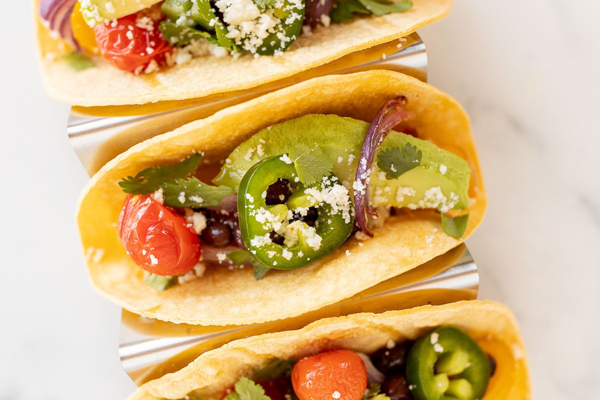 A plate of vegetarian tacos in corn tortillas