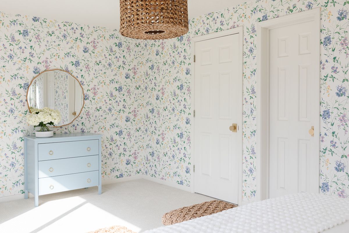 A bedroom with floral wallpaper and a dresser painted in Benjamin Moore Slate Blue