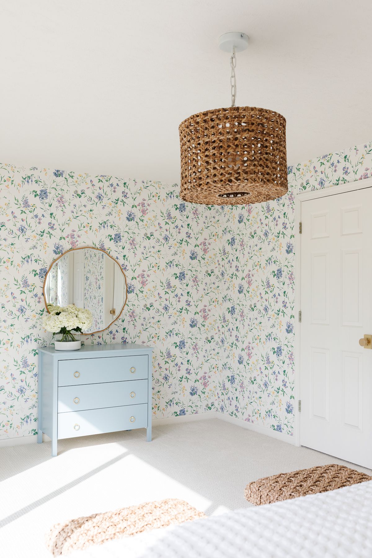 A bedroom with floral wallpaper and a dresser painted in Benjamin Moore Slate Blue