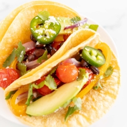 A plate of vegetarian tacos in corn tortillas