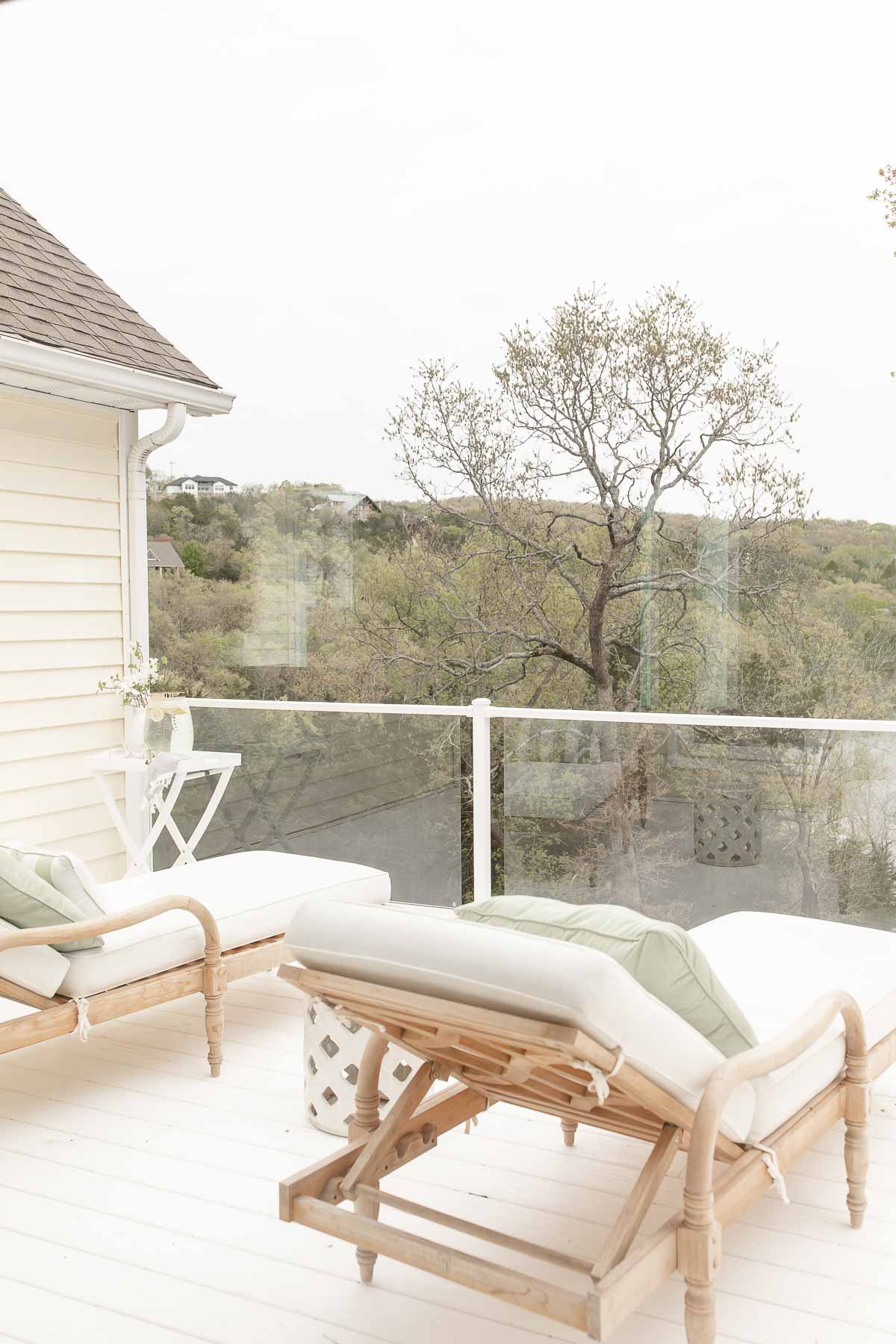 white deck with glass railing 2 teak chaise lounges