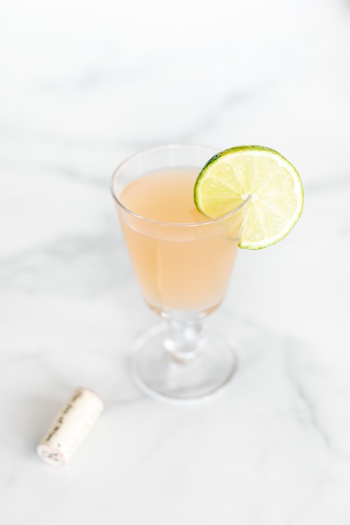 A wine margarita cocktail in a wine glass, garnished with a slice of lime