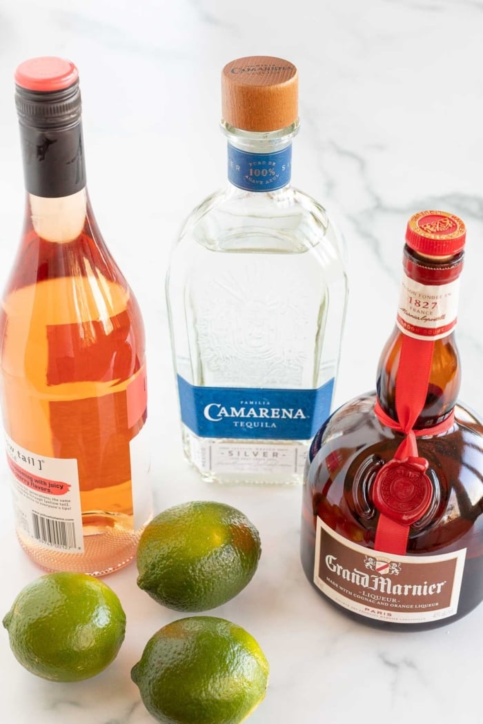 Ingredients for a wine margarita laid out on a marble surface