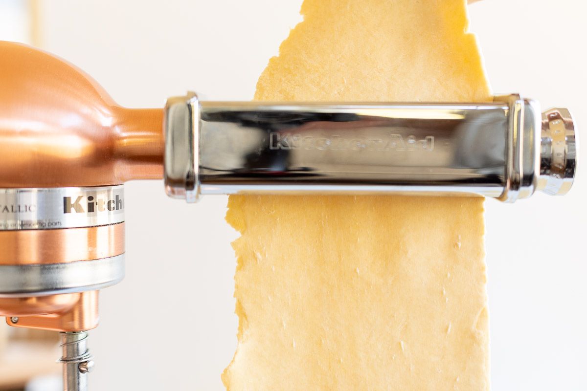 Pasta dough being passed through a pasta attachment