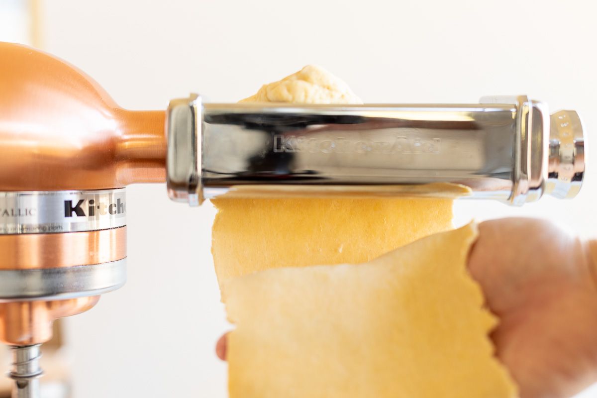 Pasta dough being passed through a pasta attachment