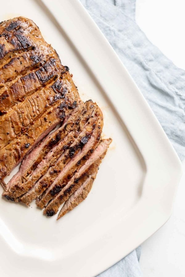 A white plate with sliced carne asada recipe