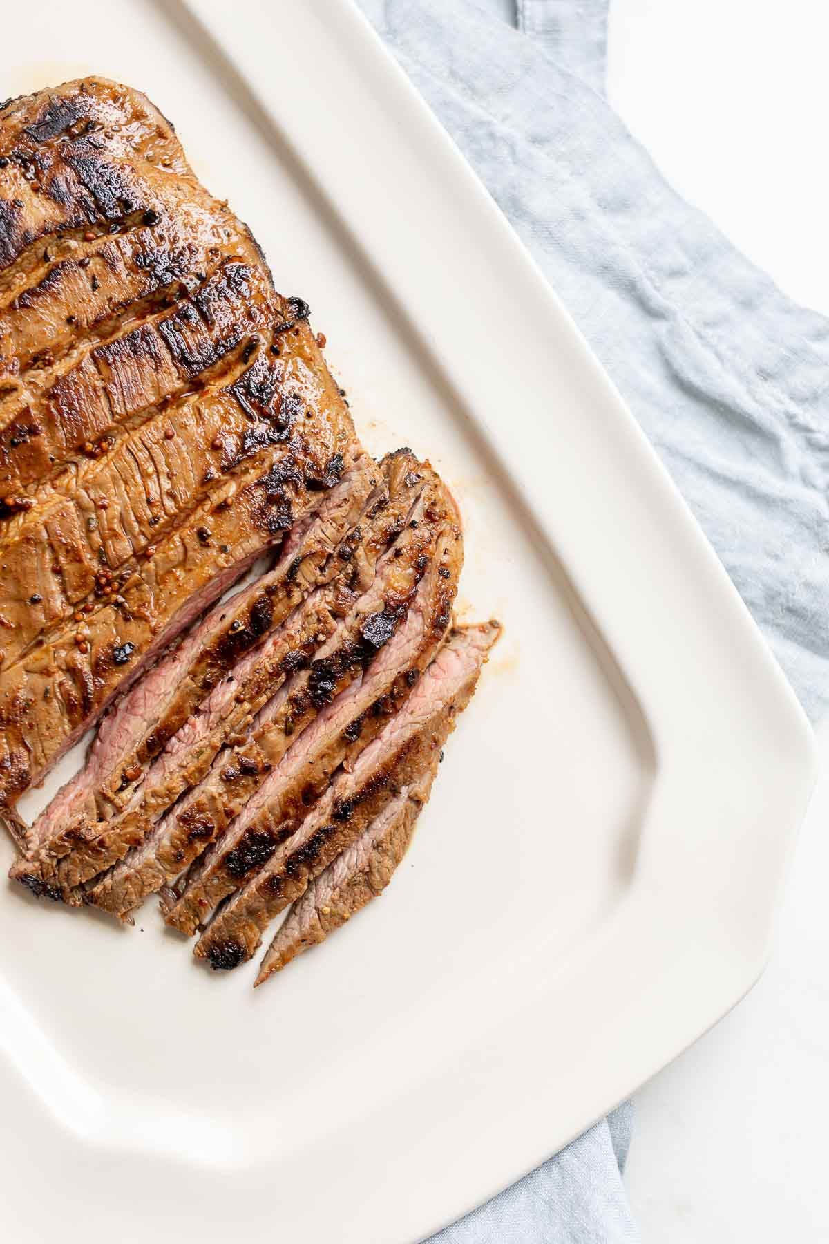 A white plate with sliced carne asada recipe