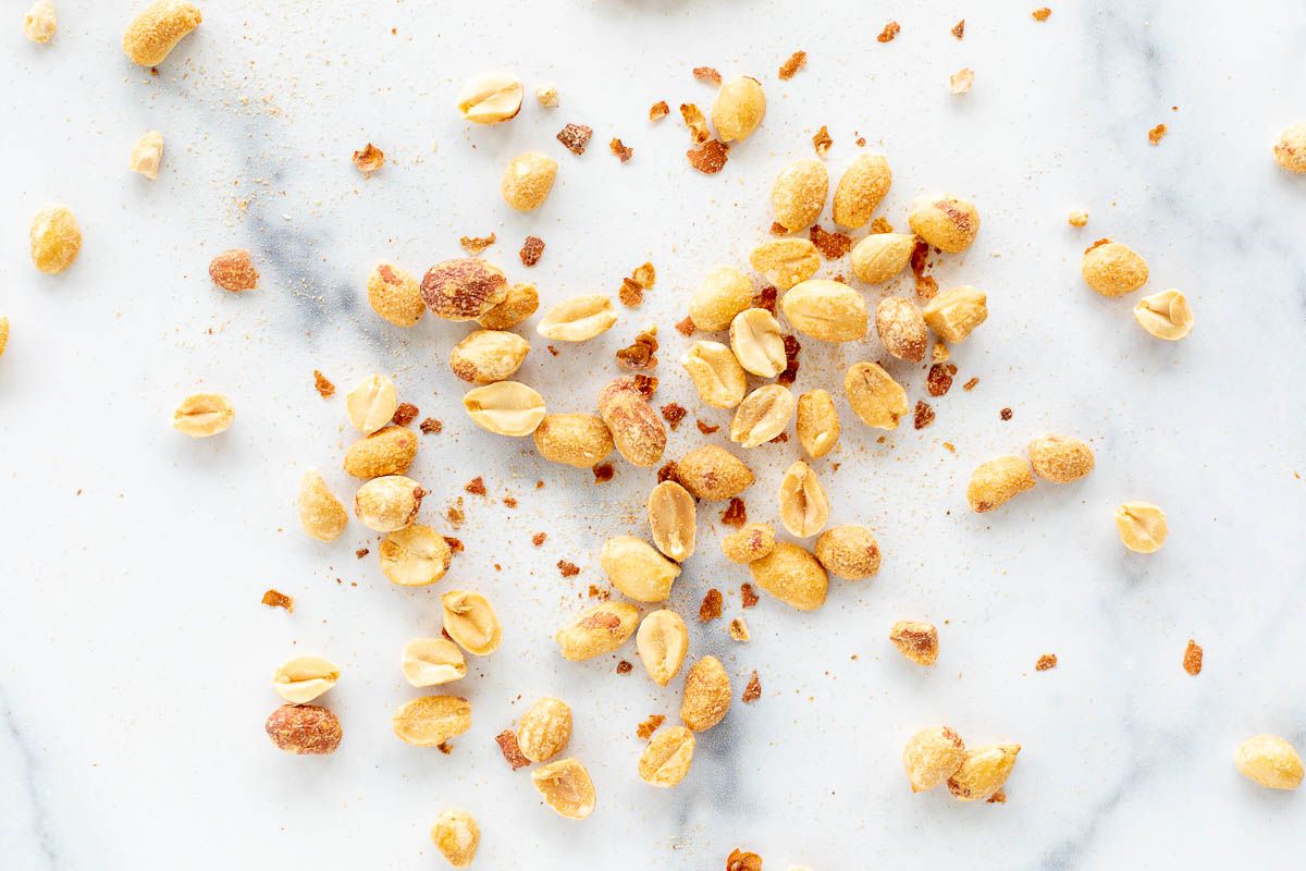 Peanuts spread out on a marble surface.