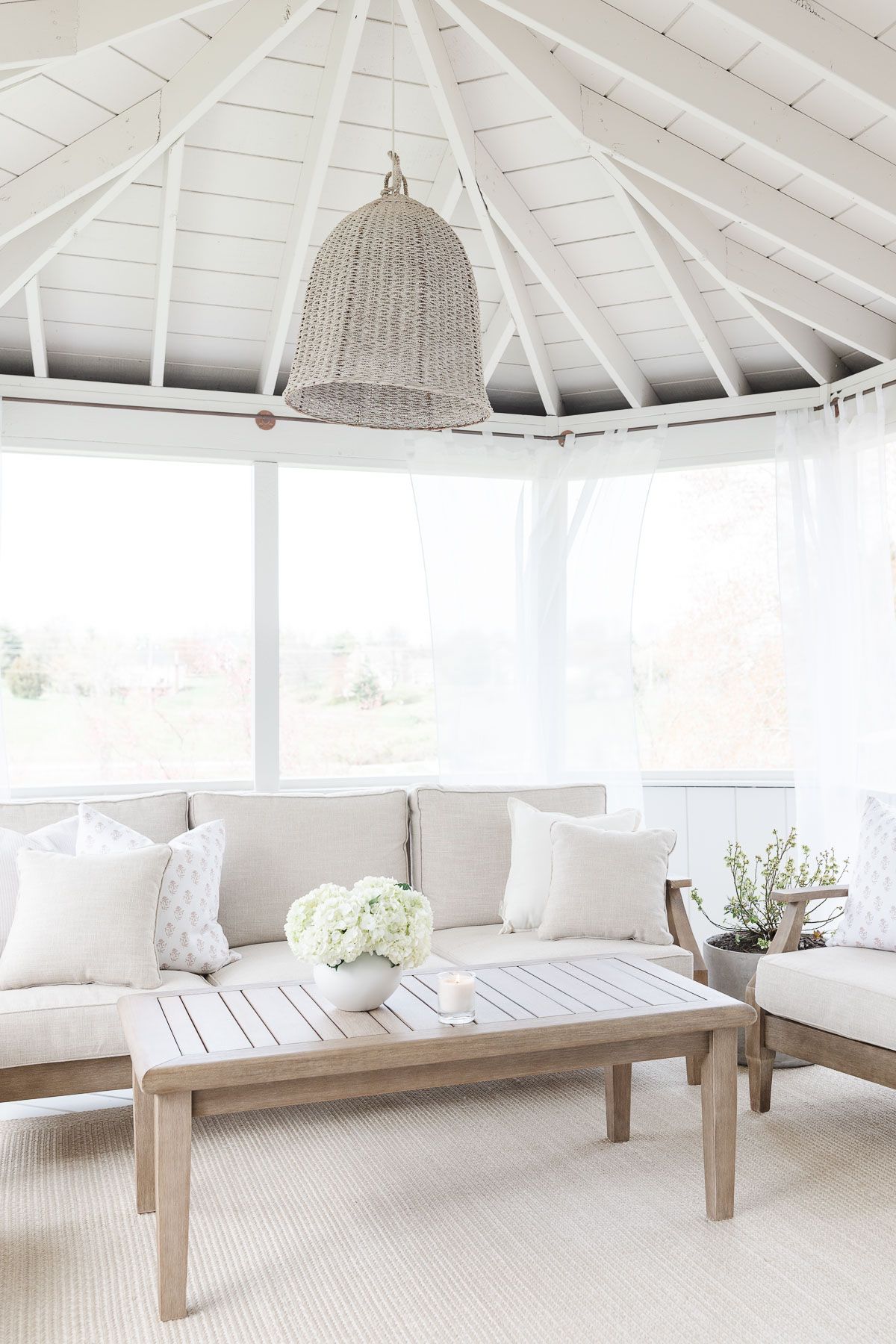 A white screened porch completed with a DIY screen porch kit.