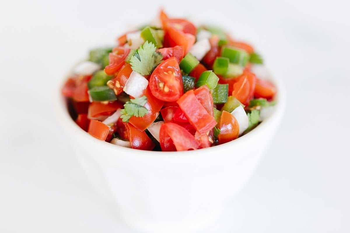 pico de gallo in a white bowl on a white background