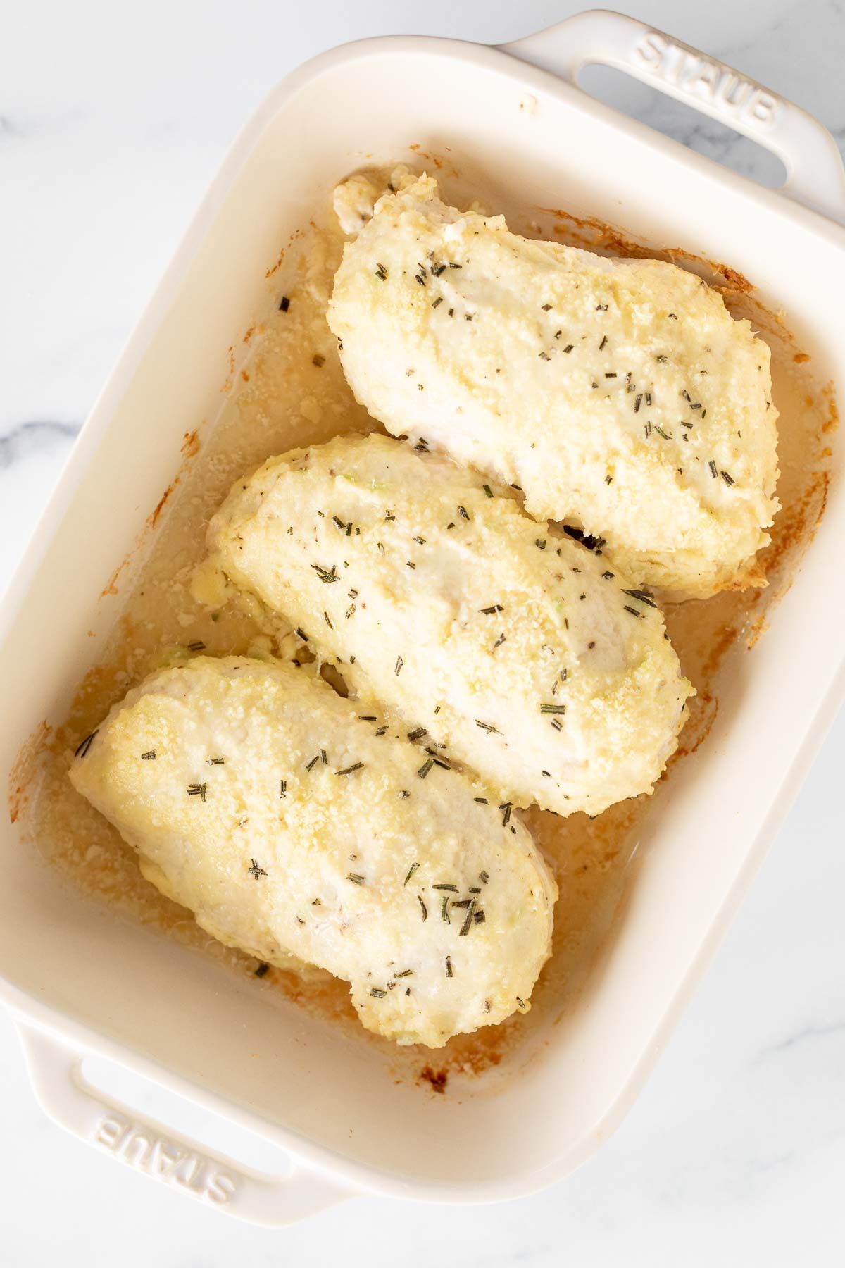 Mayo Parmesan chicken breasts baked in a white dish.
