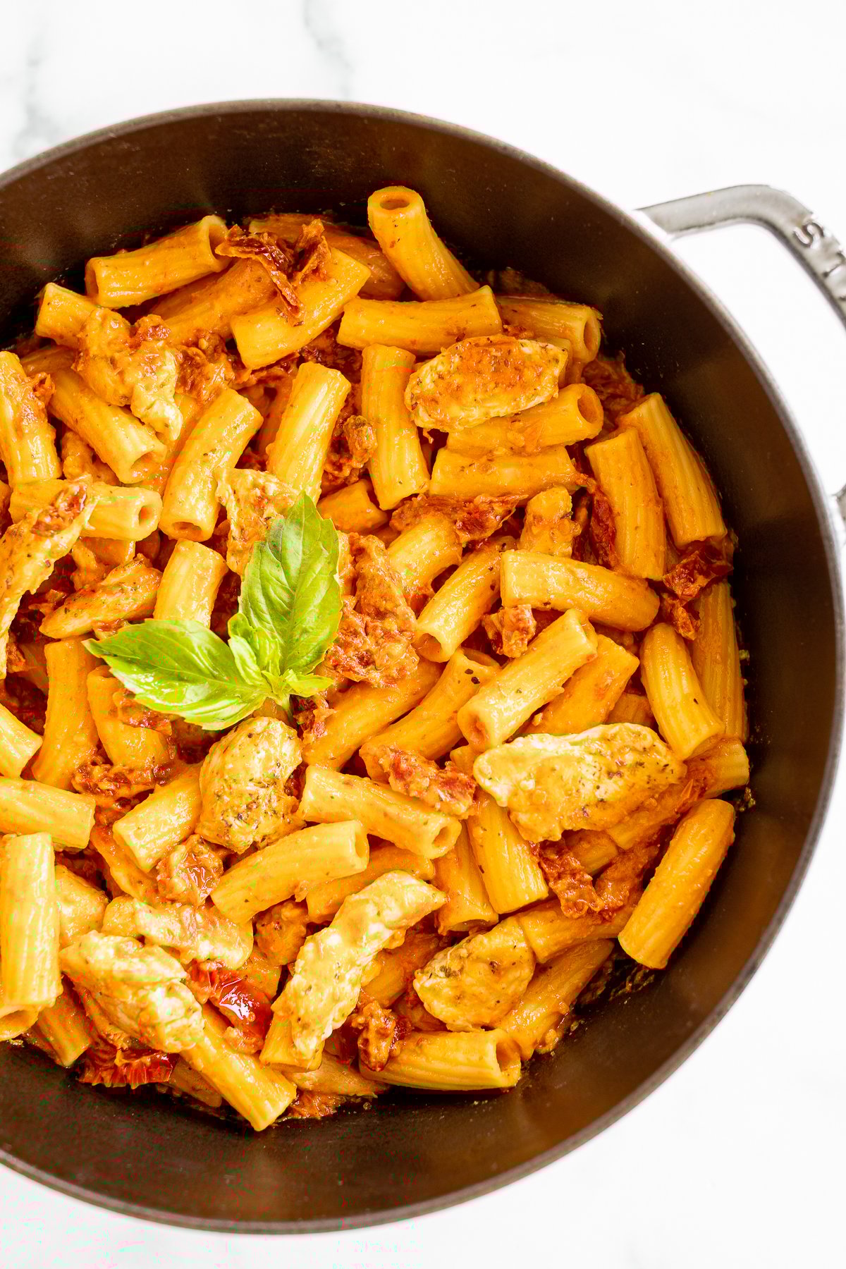 A saute pan filled with a sundried tomato chicken pasta recipe