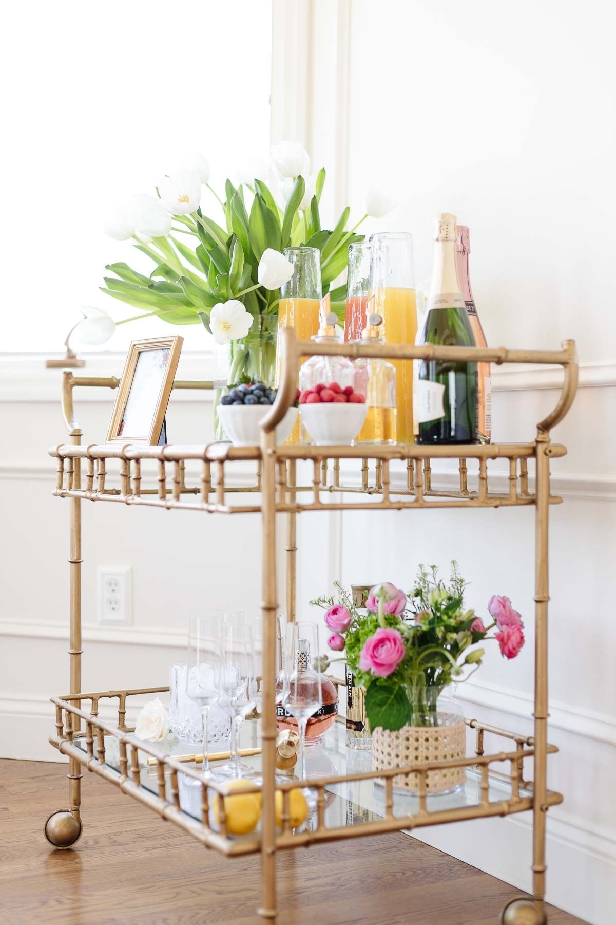 A mimosa bar set up on a gold bar cart