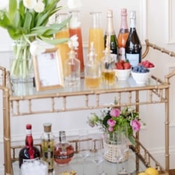 A mimosa bar set up on a gold bar cart