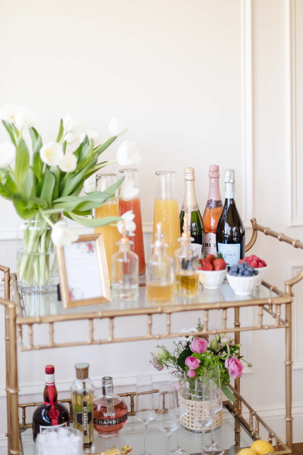 A mimosa bar set up on a gold bar cart