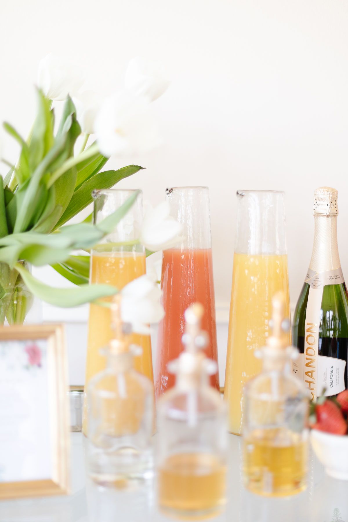 mimosa bar ideas with white tulips and fresh juices in glass bottles