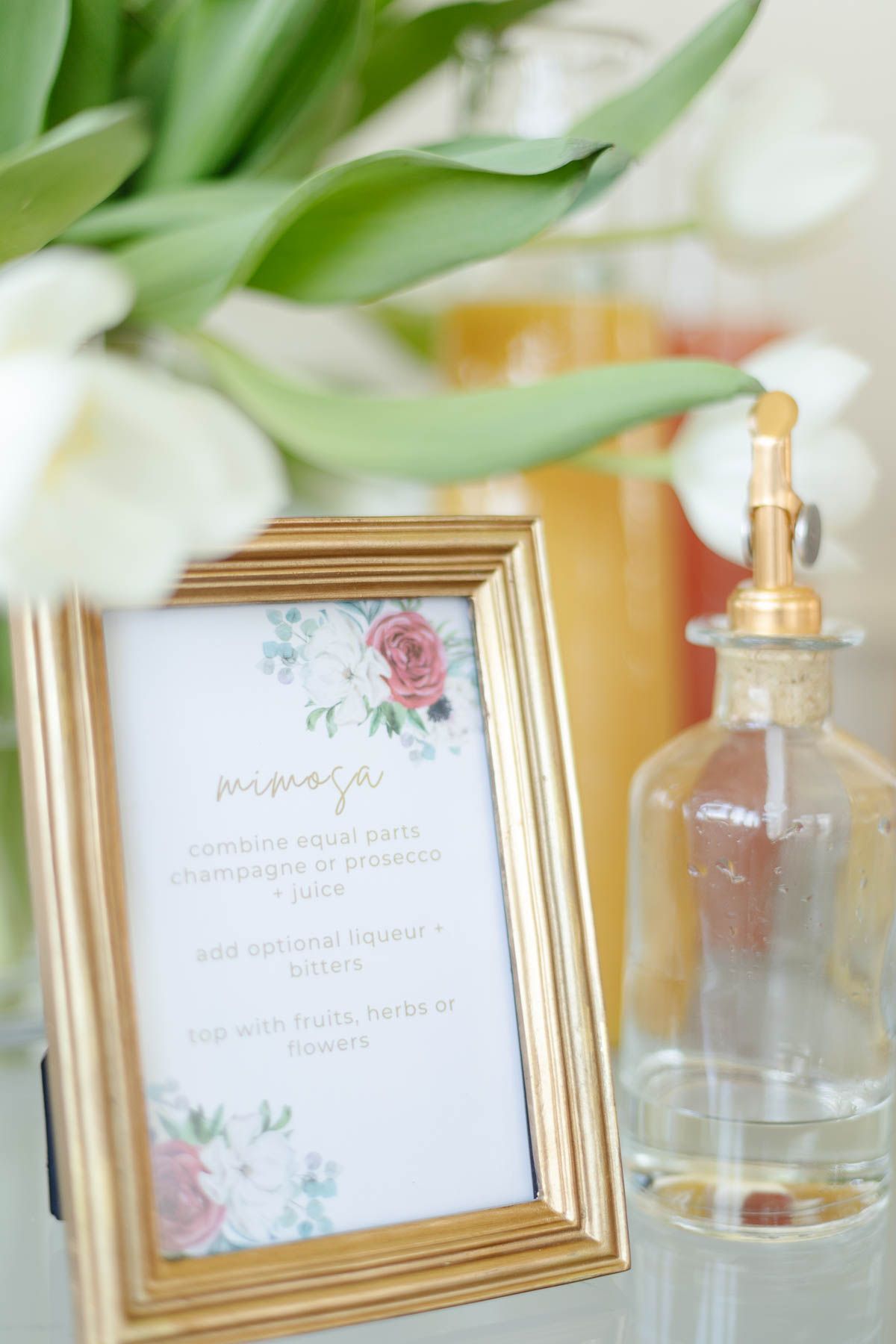 A small gold framed sign on a mimosa bar
