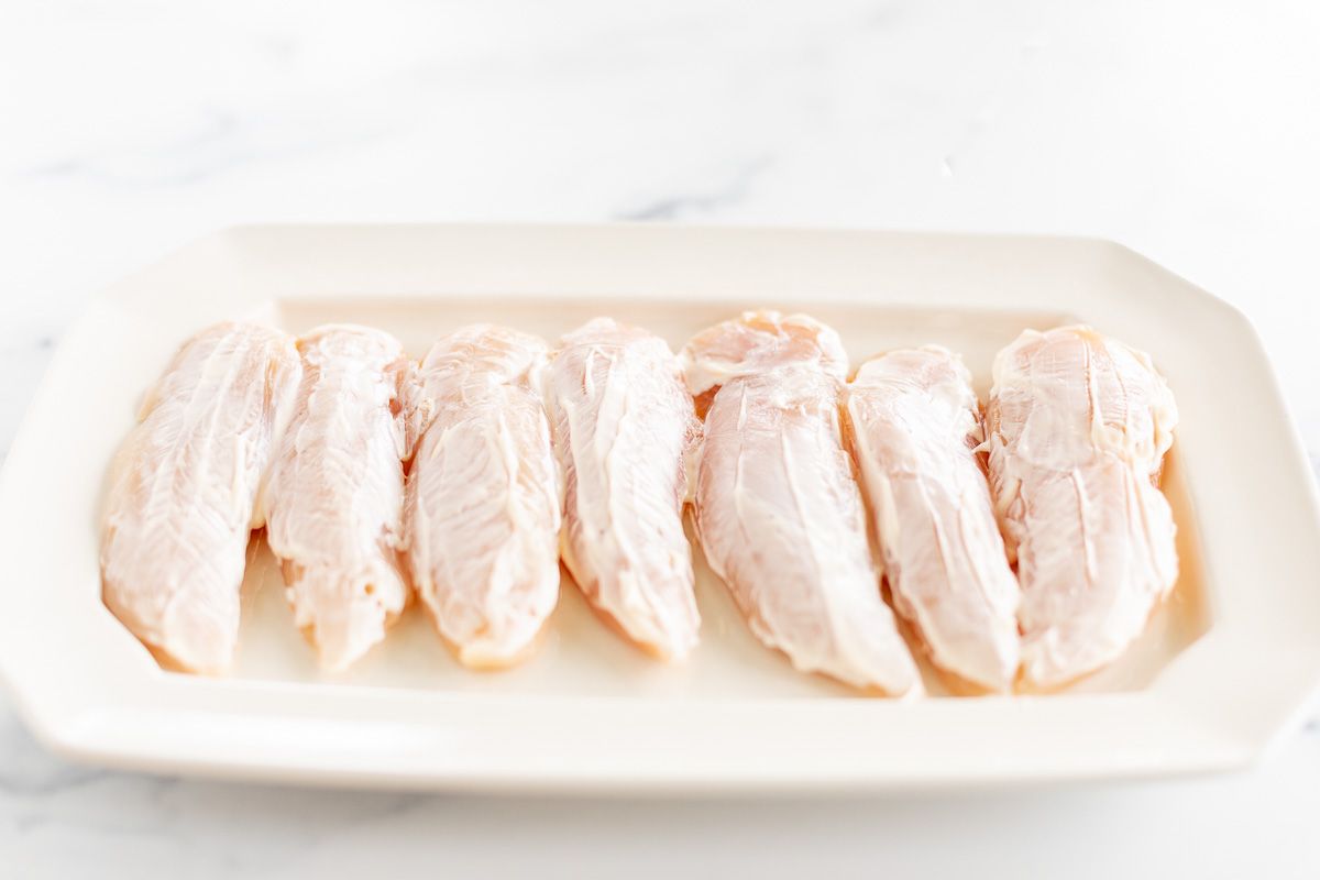 Chicken tenders, uncooked, covered in mayonnaise