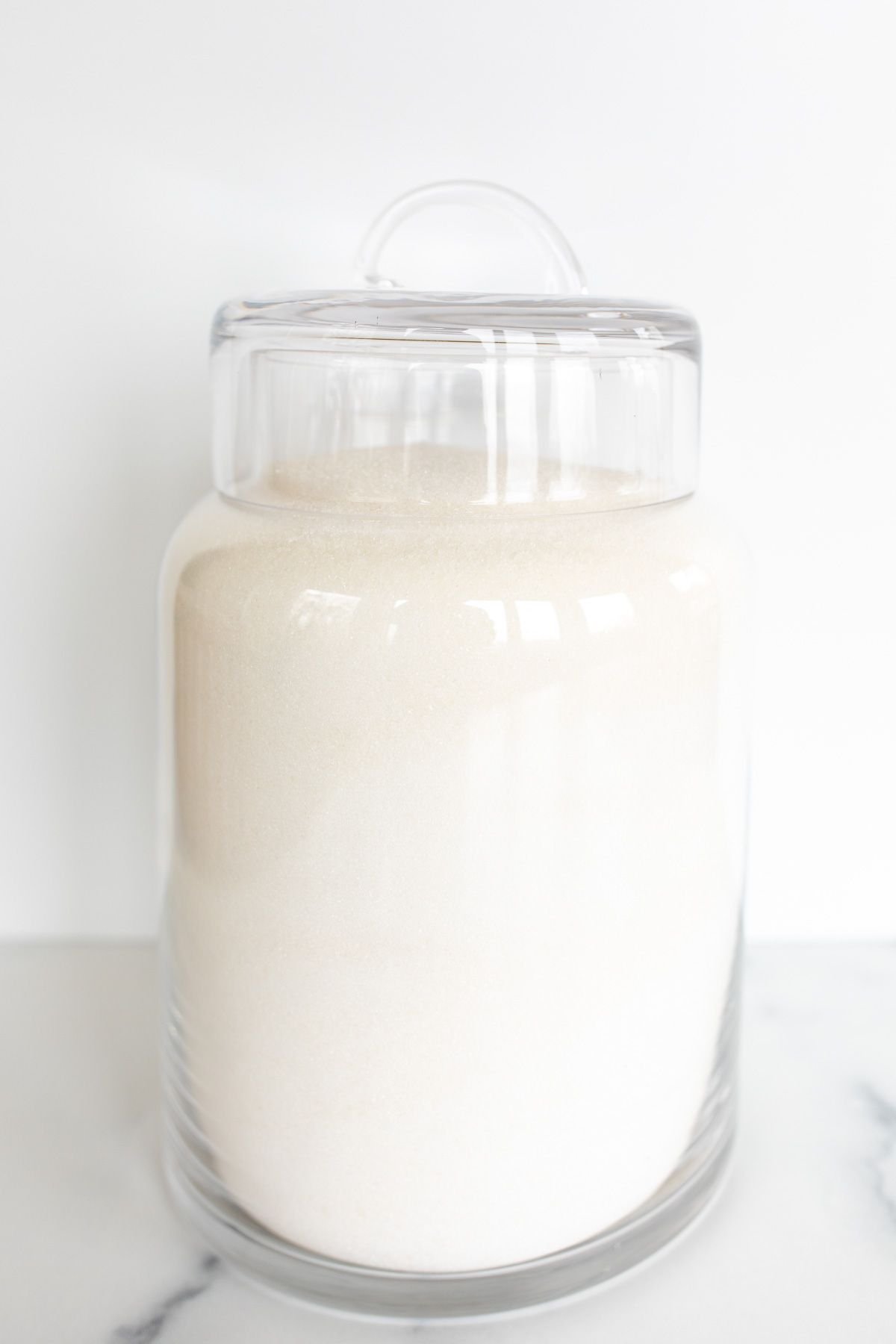 A glass canister full of homemade powdered sugar