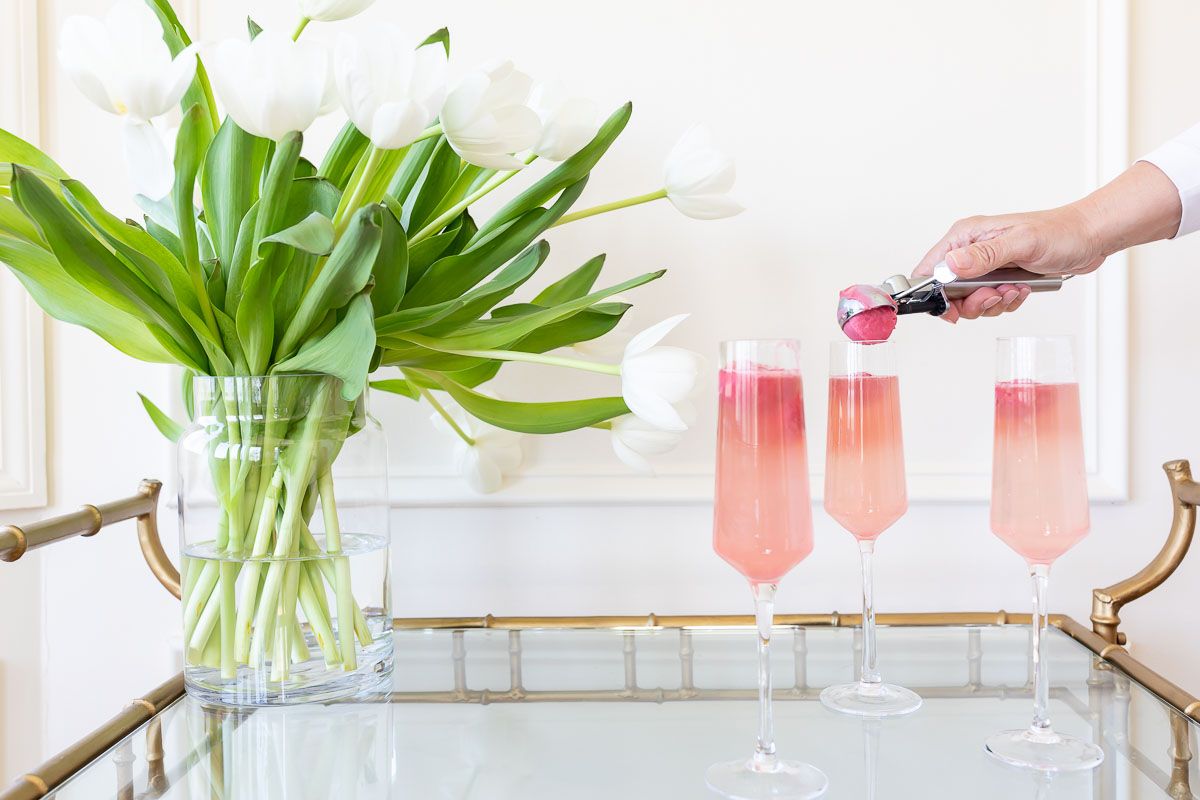 A gold rolling bar with three glasses of sorbet mimosas