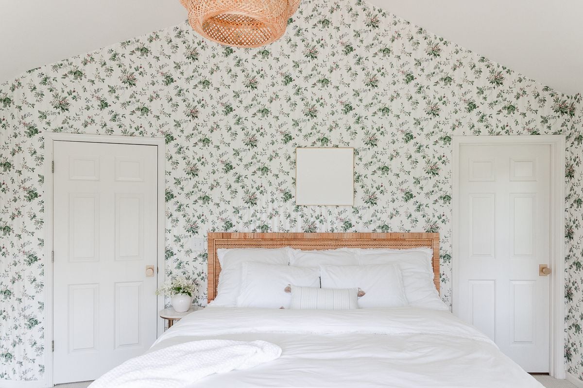 A wallpapered bedroom with white textured wall art over the bed