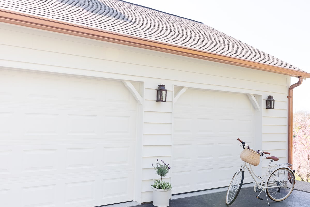 cream tudor garage with copper gutters and bike