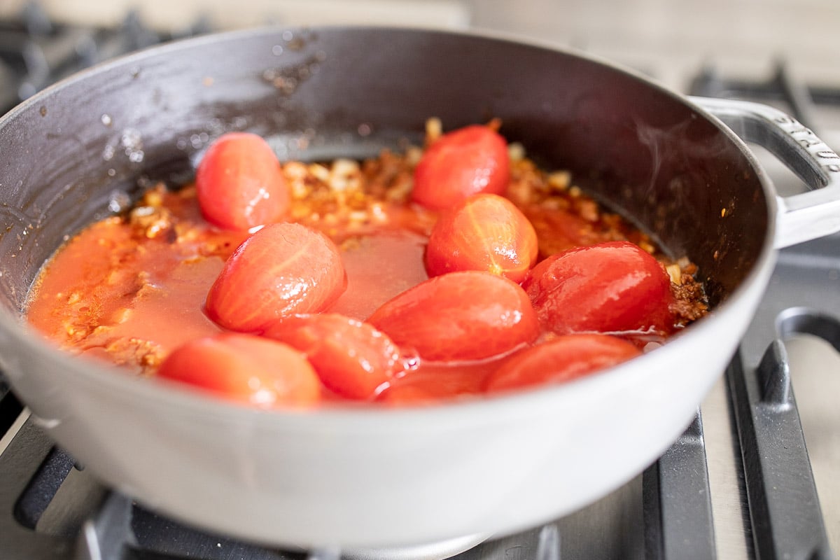 tomatoes in a cast iron skillet on a stove top