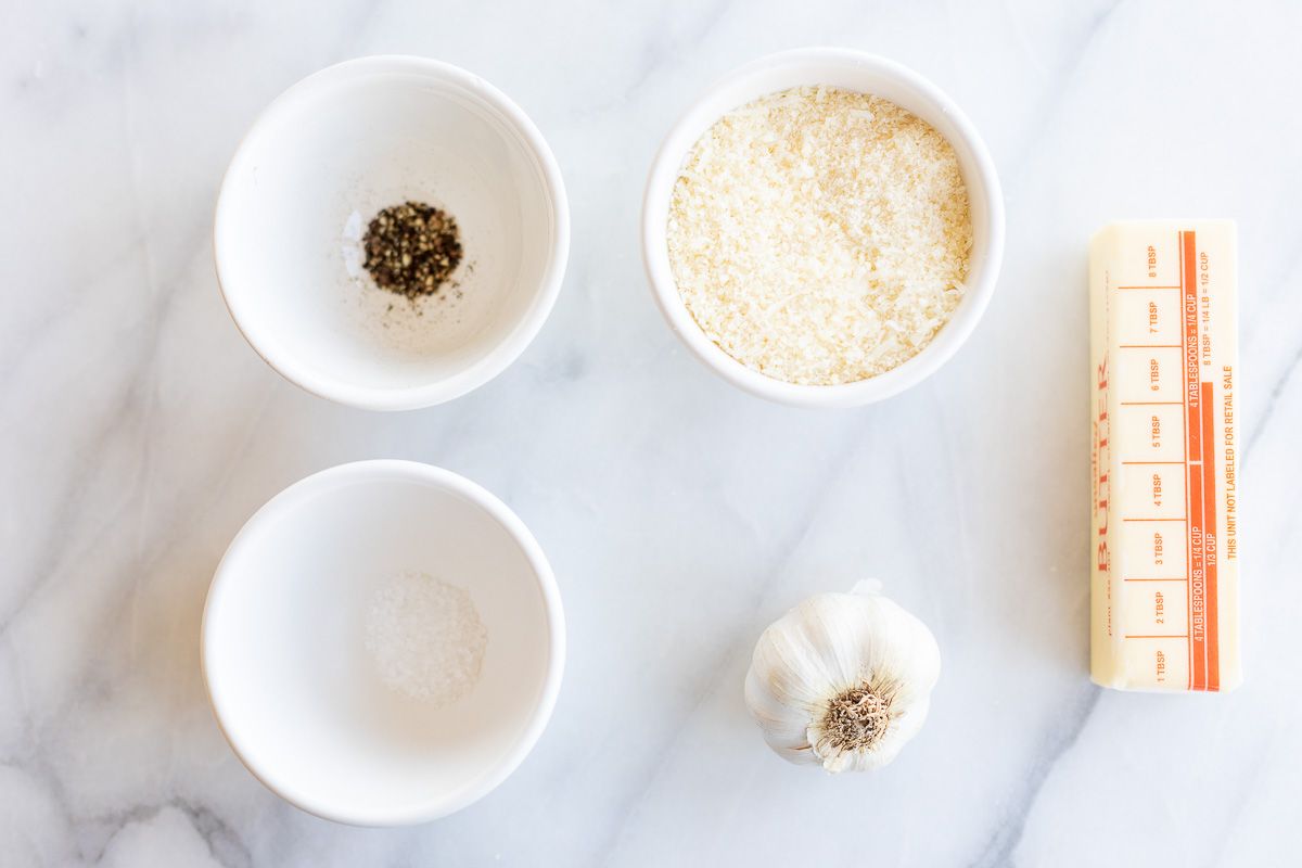 Ingredients for garlic parmesan pasta laid out on a marble surface