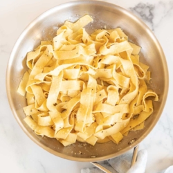 buttered garlic parmesan pasta in a silver pan