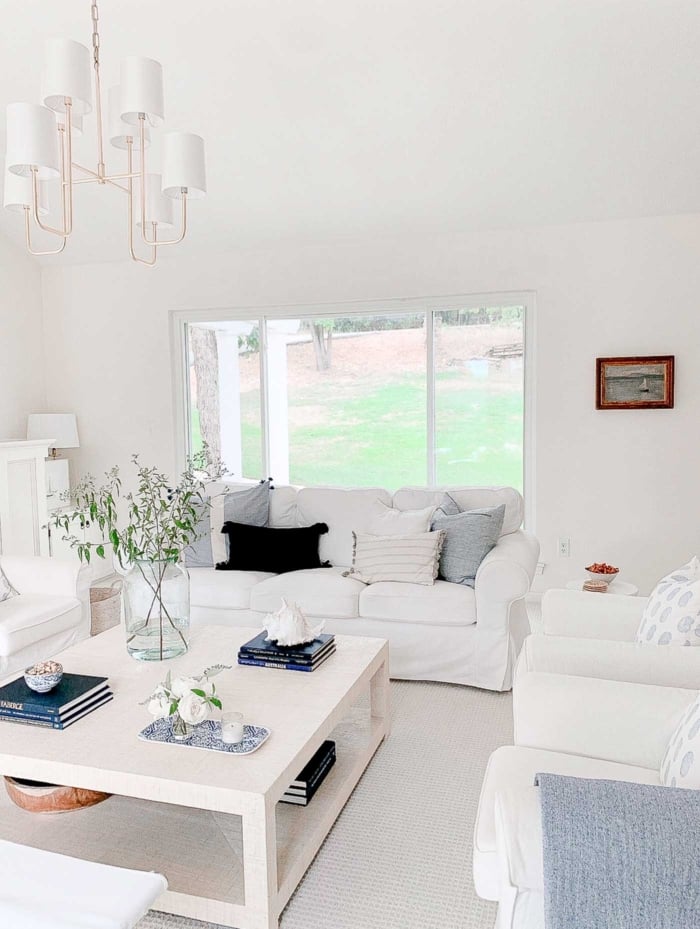 A white coffee table with soft blue and white coffee table decor. 