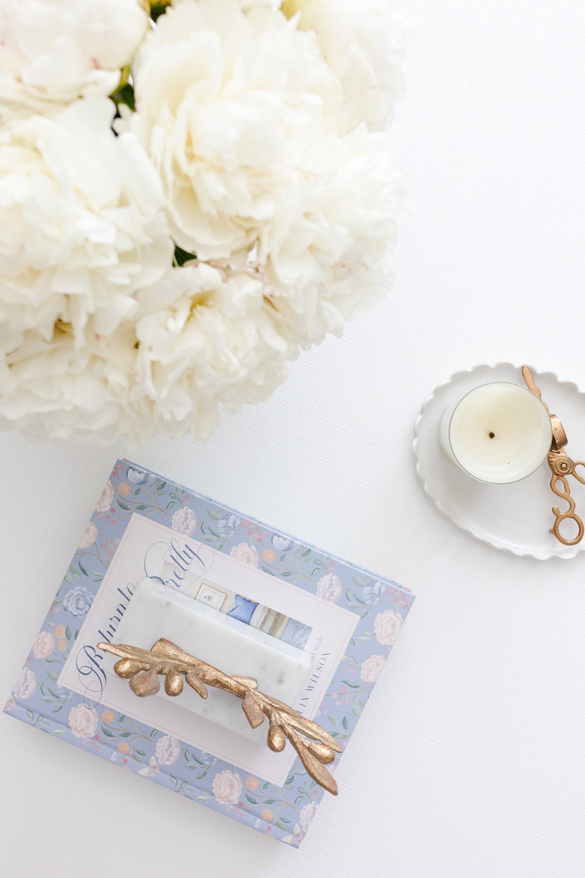 A white coffee table with soft blue and white coffee table decor.