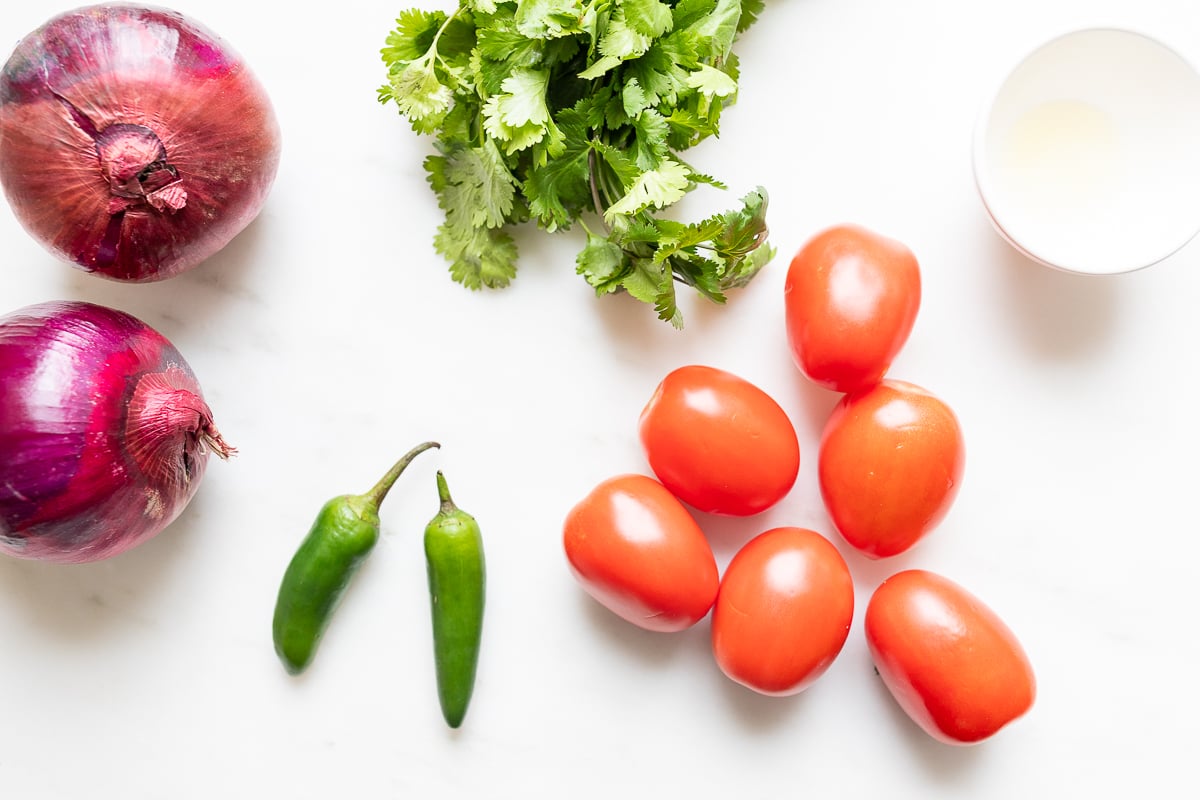 ingredients for pico de gallo on a white surface