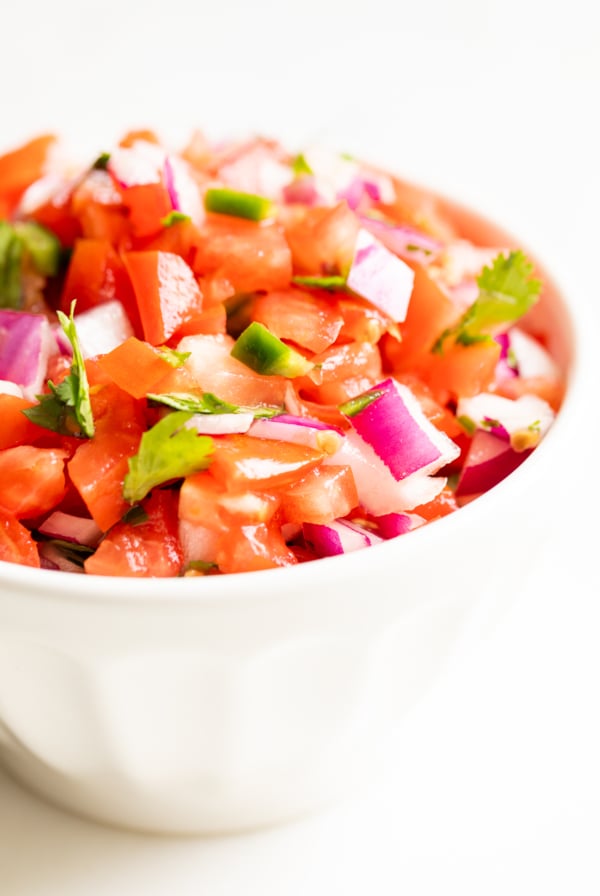 A white bowl of pico de gallo