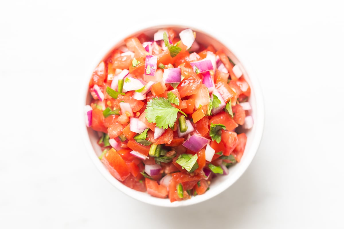 A white bowl of pico de gallo