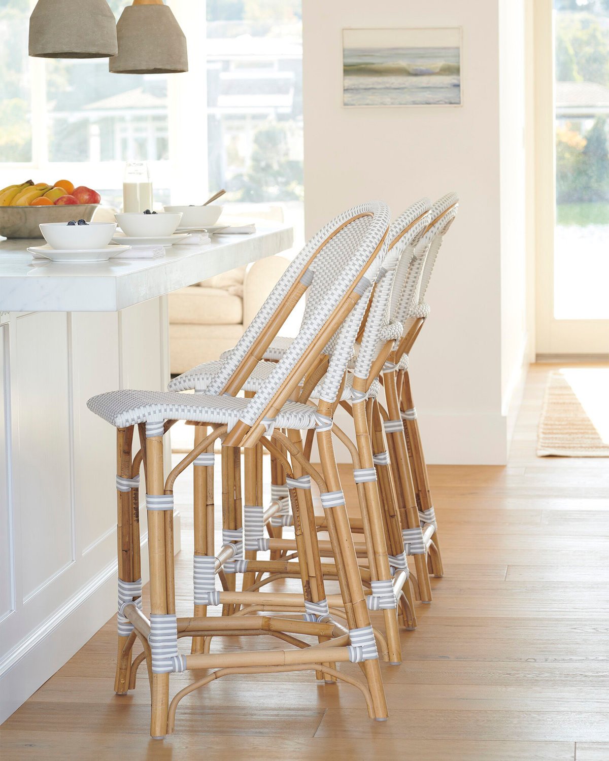 Rattan bar stools at a white kitchen island