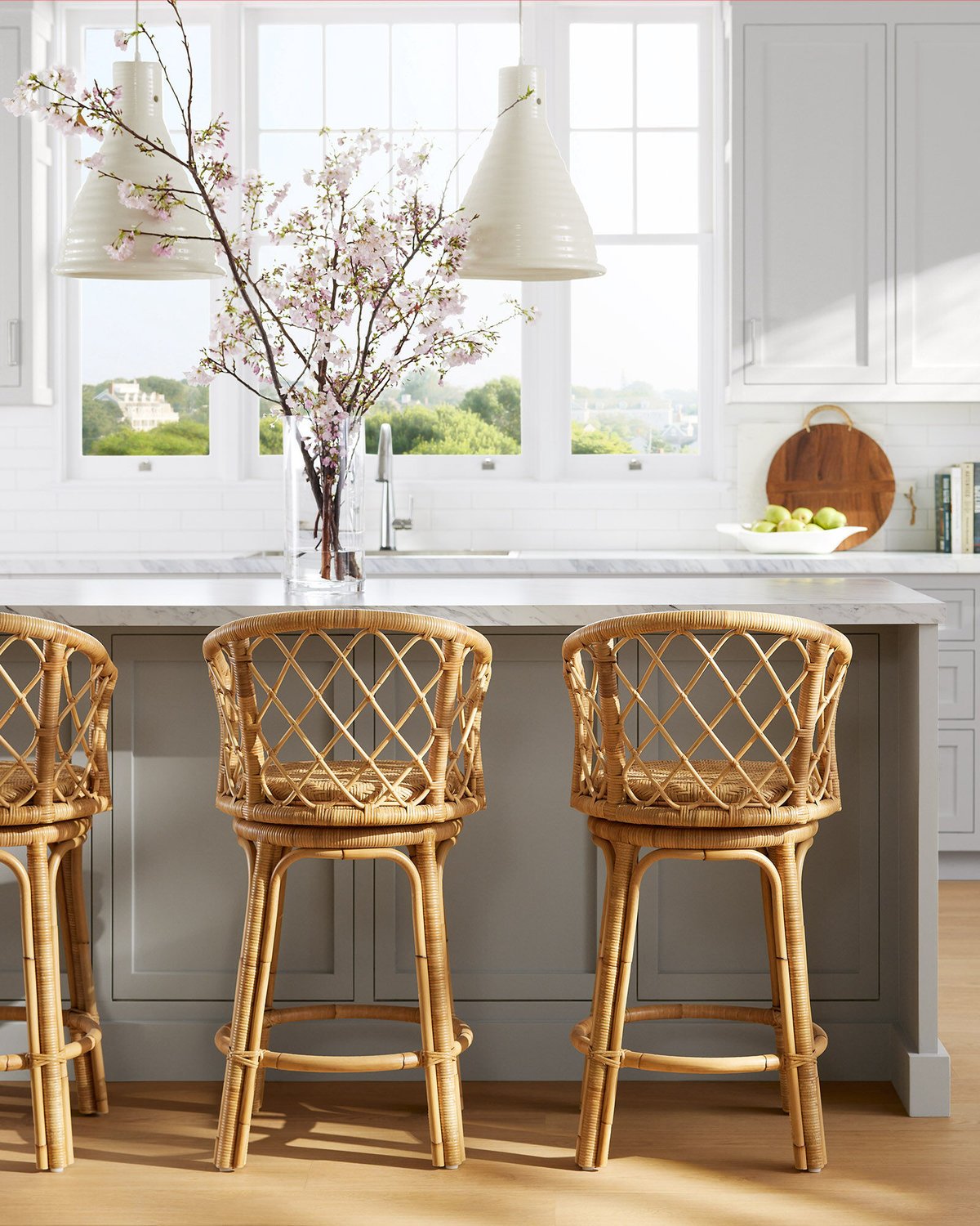 Rattan bar stools at a gray kitchen island