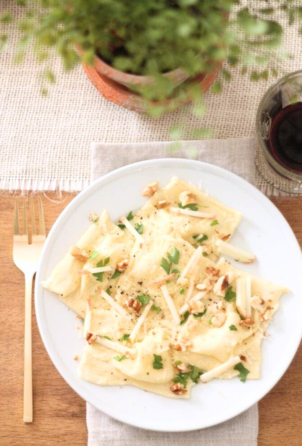 A plate of pasta with parmesan cheese and walnuts.