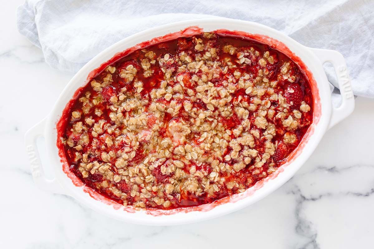 A strawberry crumble in a white oval baking dish