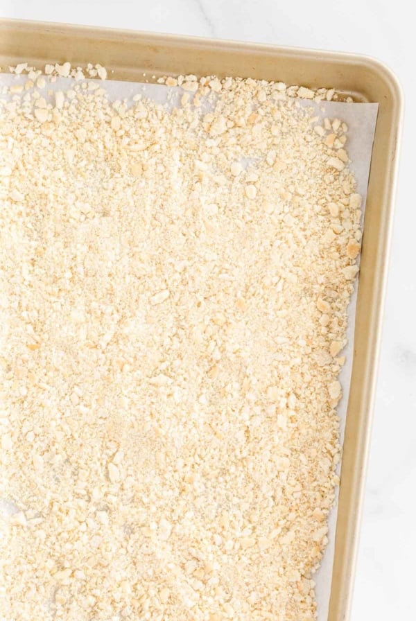 A panko substitute breadcrumb on a gold baking sheet lined with parchment paper