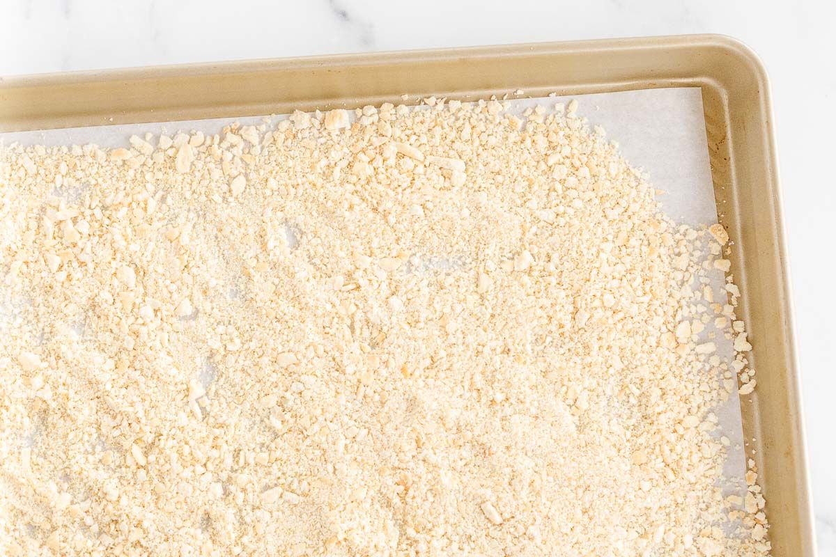 A panko substitute breadcrumb on a gold baking sheet lined with parchment paper