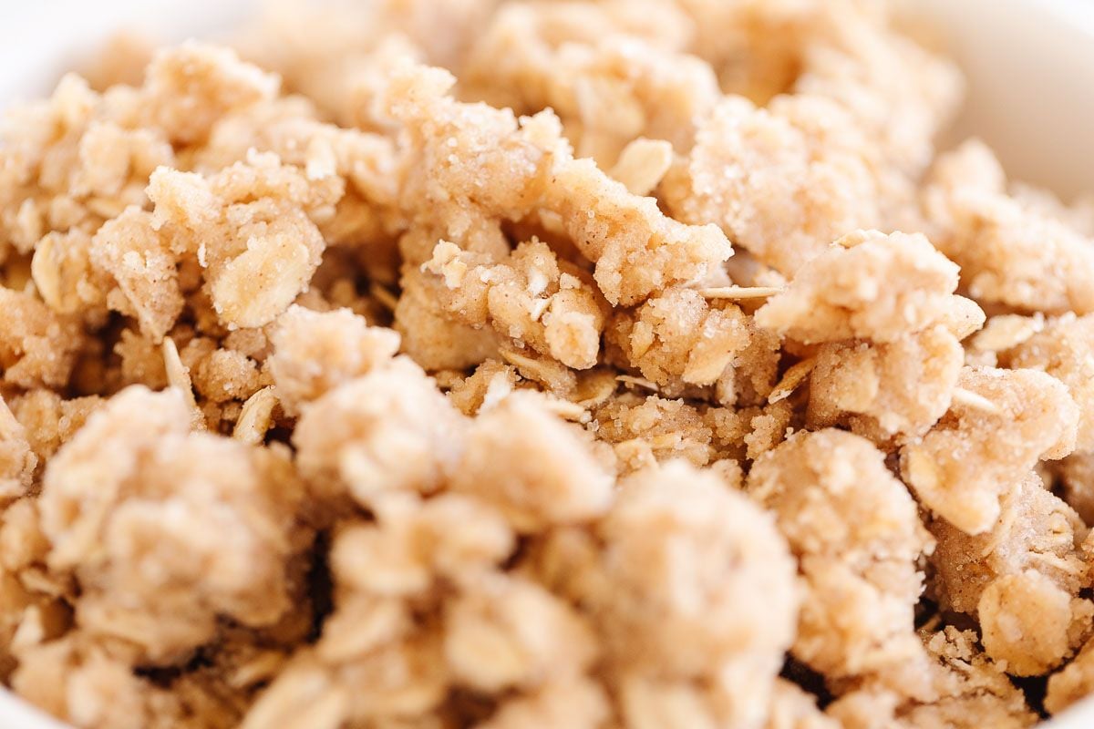 A small bowl full of a crumble topping with oats, prior to being baked on top of a dessert.