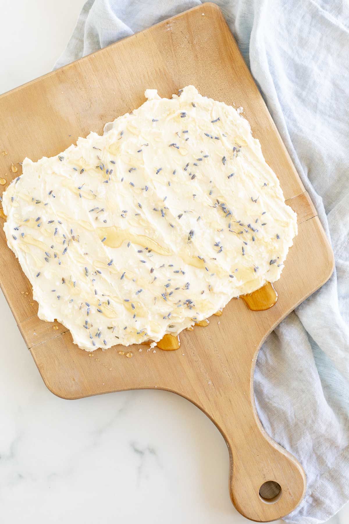 The beginning of a butter board, with a blue linen towel in the background