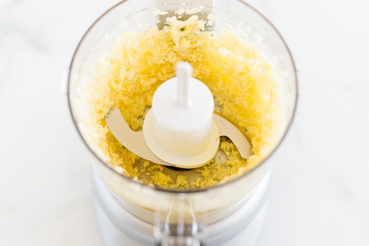 The inside of a food processor filled with homemade garlic paste