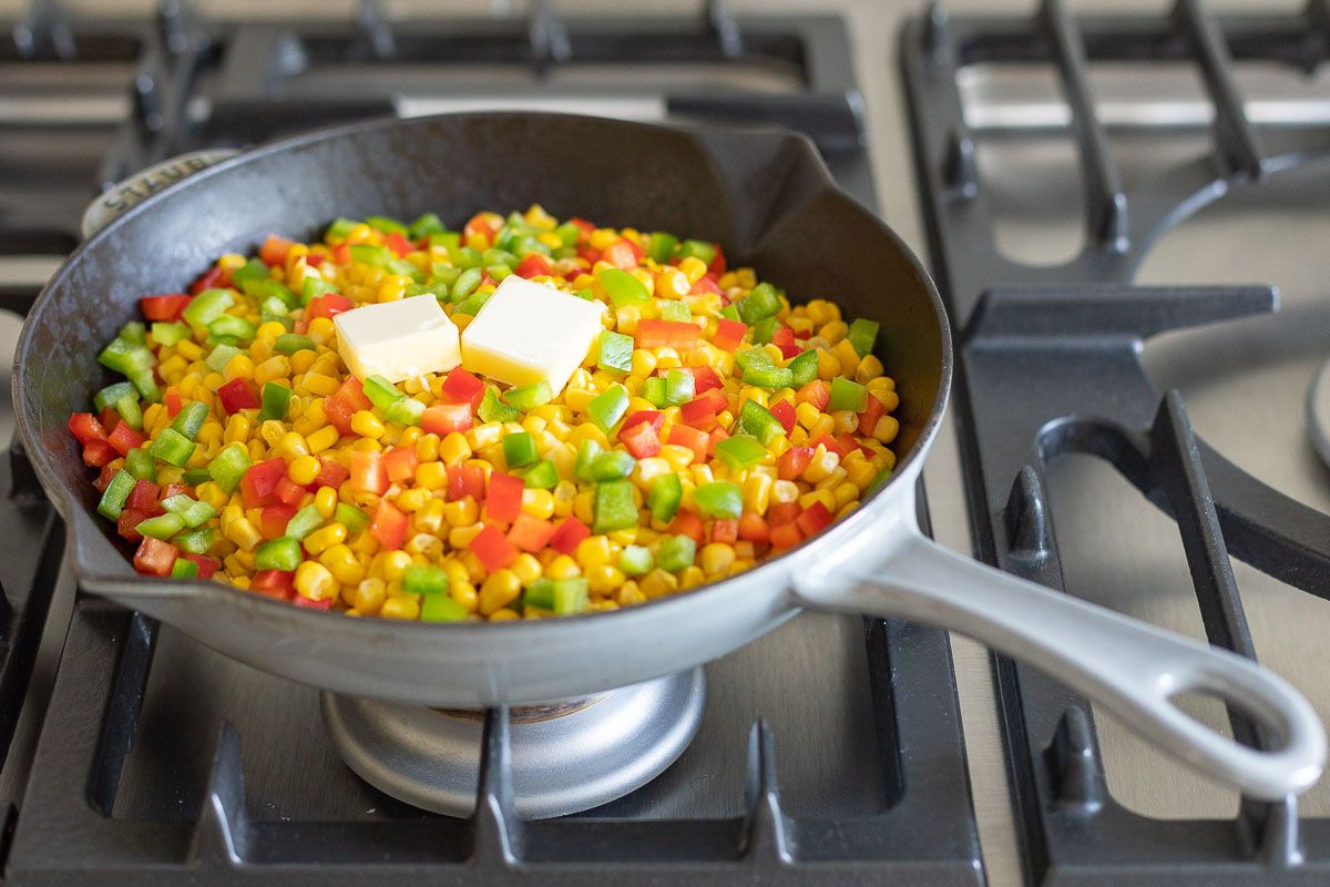 A saute pan filled with homemade mexicorn, with two pats of butter on top. 