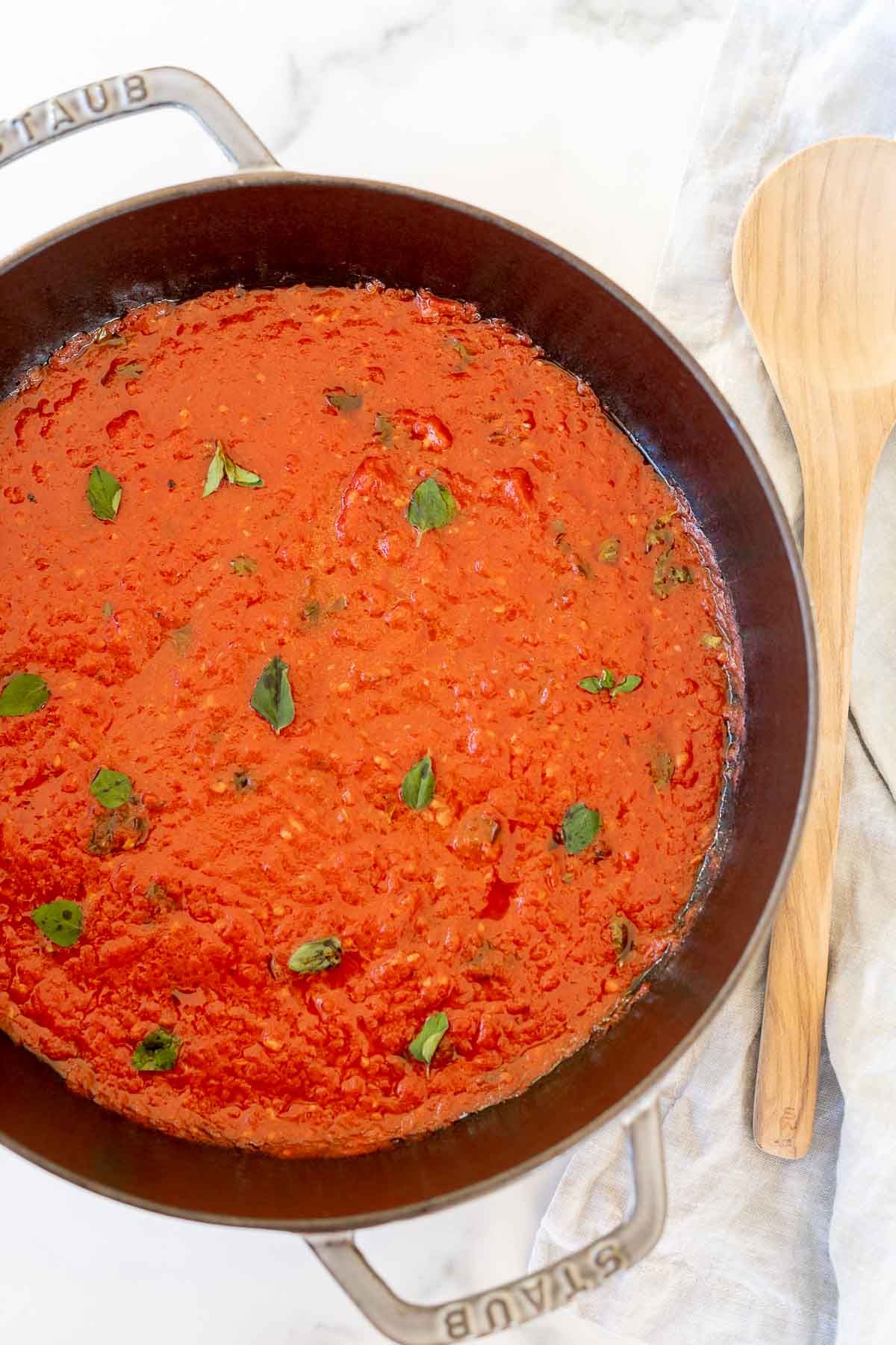 San Marzano tomato sauce in a cast iron pan, topped with chopped herbs.