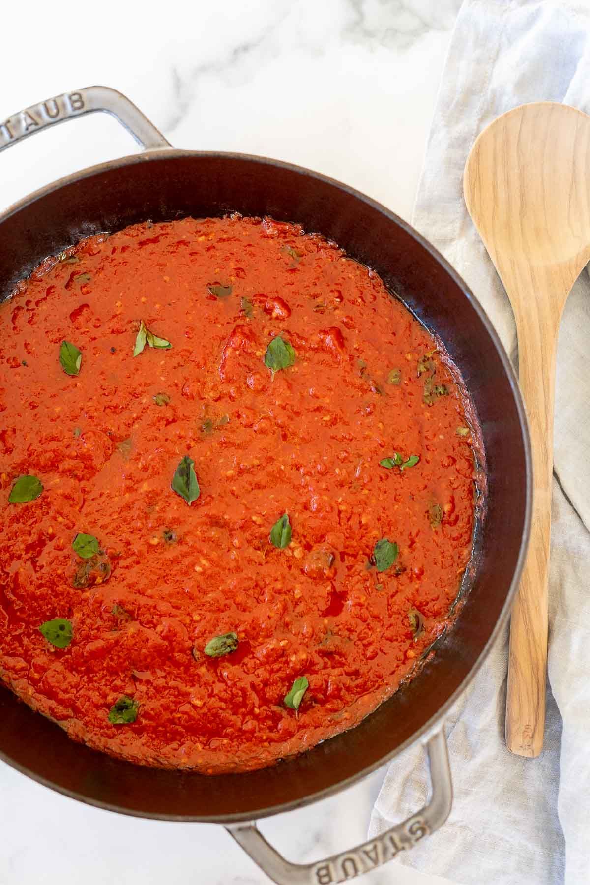 San Marzano tomato sauce in a cast iron pan, topped with chopped herbs.