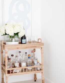 rattan bar cart with blue and white art over