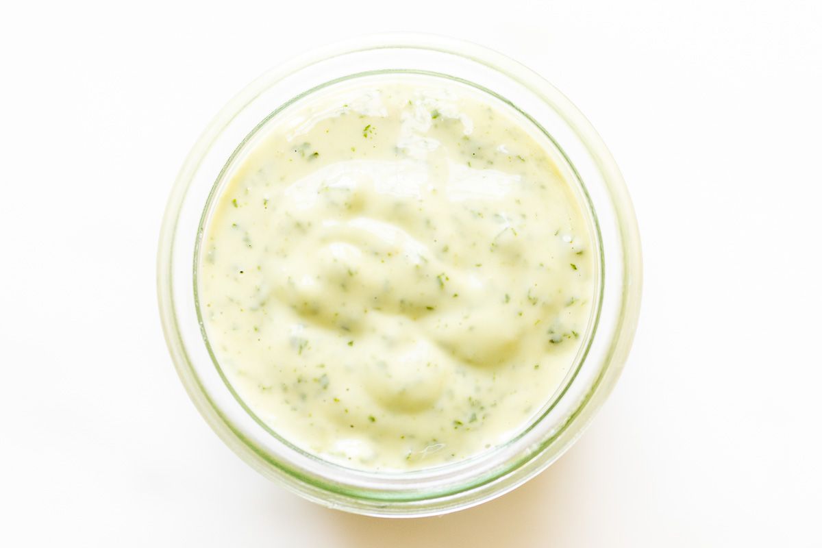 A small glass jar full of pesto aioli.