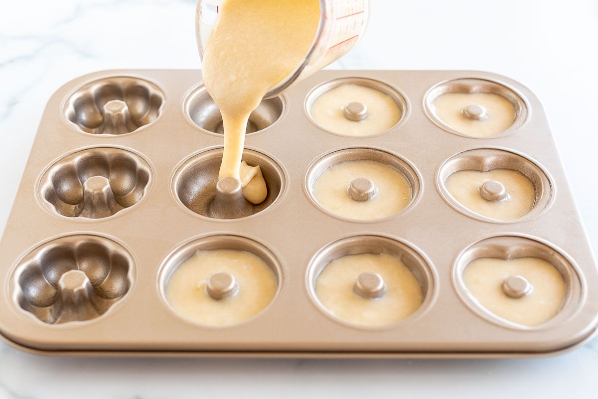 Batter pouring into a donut pan.